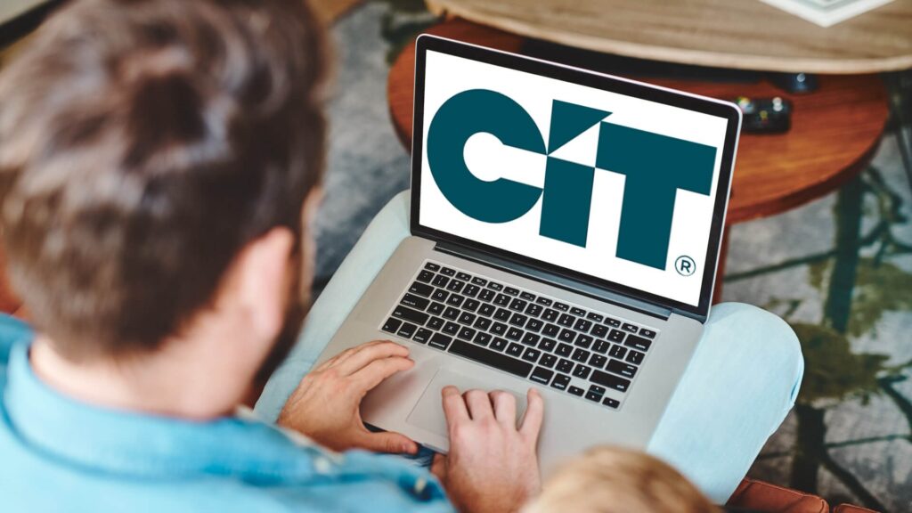 Man Operating His Laptop with the CIT logo on his screen