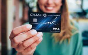 A woman holding a Chase credit card